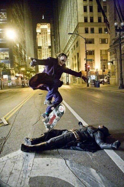 Хит Леджер в роли Джокера перепрыгивает на скейтборде через Кристиана Бейла в роли Бэтмена во время перерыва на съемках Темного Рыцаря.