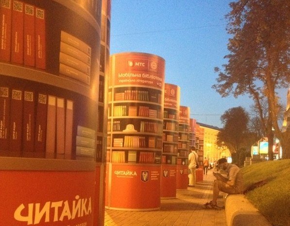 Вот такие штуки установил МТС в Киеве. Суть в том, что эти тумбы раздают WiFi, а на каждой нарисованной книге есть QR-код. Ты код считываешь и грузишь книгу.