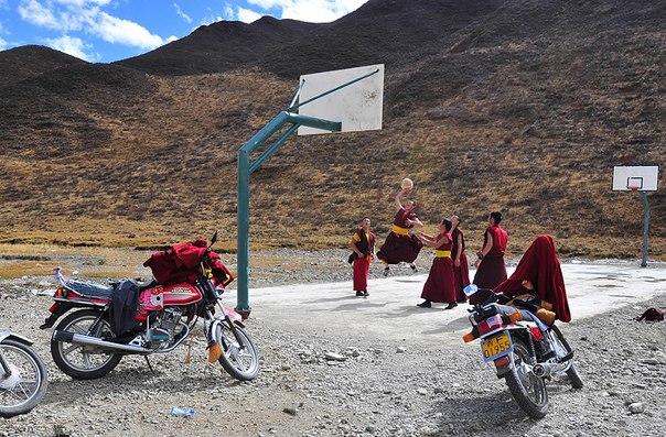 Монахи, играющие в баскетбол неподалеку от своего монастыря. Провинция Цинхай, Китай.