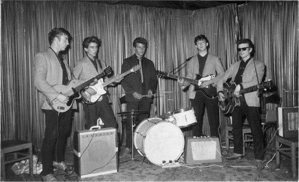 Первый состав группы The Beatles. В него входили Пол Маккартни (бас-гитара, гитара, вокал), Джон Леннон (гитара, вокал), Джордж Харрисон (гитара, вокал), Стюарт Сатклифф (бас-гитара), Пит Бест (ударные).  Фотография сделана во время первой поездки Гамбург в 1960 году.