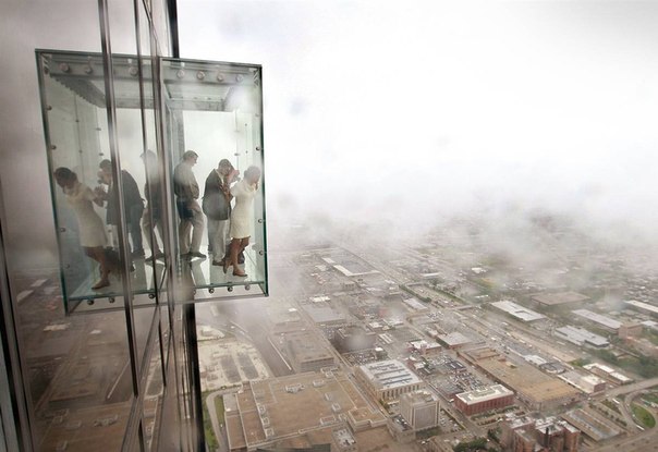 Посетители любуются видом из The Ledge, новый смотровой площадки на самом высоком небоскребе США, Сирс Тауэр в Чикаго. Она находится на 103 этаже (около 412 метров) и открыта для посещения публики.