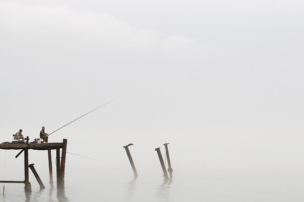 Рыбаки во время тумана над Черным морем. Город Сочи, Россия.