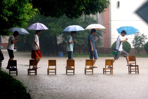 Китайские студенты нашли оригинальный способ перебраться через затопленную дорогу в Ухане.