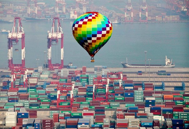 Воздушный шар летит над цветными контейнерами в порту Циндао, провинция Шаньдун, Китай.