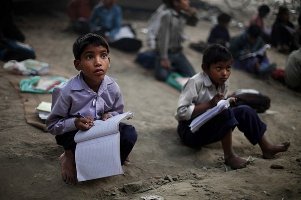 Фотограф Альтаф Кадри обнаружил в Нью-Дели, Индия, необычную школу. В ней есть учителя, ученики, две доски, стул и больше ничего — ни парт, ни самого здания школы. Дети из трущоб познают азы математики, учатся писать и читать прямо на улице под мостом.