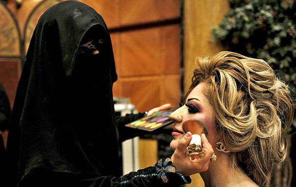 Женщина из Саудовской Аравии наносит макияж модели перед конкурсом красоты и стиля на выставке косметики.
