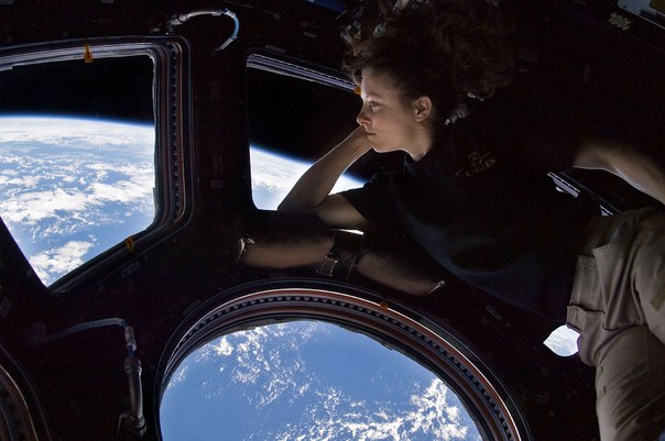 Астронавт Трейси Колдуэлл-Дайсон смотрит на Землю с борта МКС.