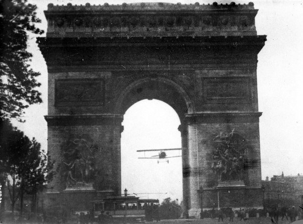 Авиатор Шарль Годфруа пролетает через Триумфальную арку на своем самолете «Nieuport 11». Париж ,Франция. 7 августа 1919 года.