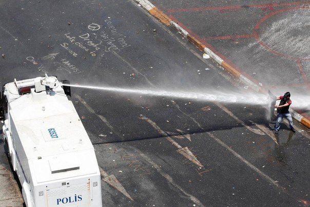 Полиция применяет водометы и слезоточивый газ, разгоняя протестующих на площади Таксим, Стамбул, Турция. 