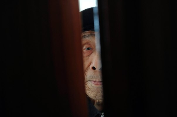 Старик смотрит в проем двери в доме для престарелых в Хэфэе.