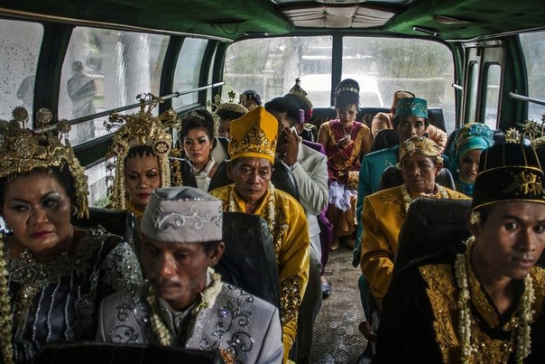 Пары, ожидающие отправления на массовую свадебную церемонию для бедных в Джокьякарте, Индонезия. 
