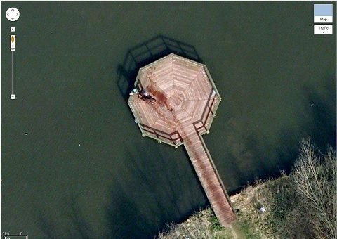 Если ввести в Google Earth координаты 52.376552, 5.198303, и увеличить, то можно увидеть как мужчина тащит труп к озеру.