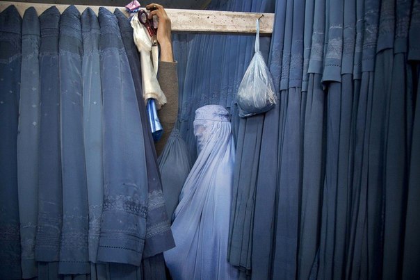 Афганская женщина в магазине, торгующем паранджой, Кабул, старый город. Сейчас женщинам официально разрешено ходить без паранджи, однако в южном Афганистане местные полевые командиры Талибана принуждают женщин носить этот вид одежды. 