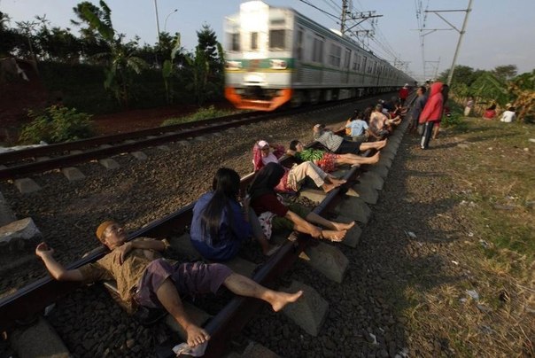 Индонезийцы лежат на железнодорожных рельсах под электрическими проводами на станции Рава Buaya. Местные жители считают, что это укрепляет здоровье, способствует профилактике болезней