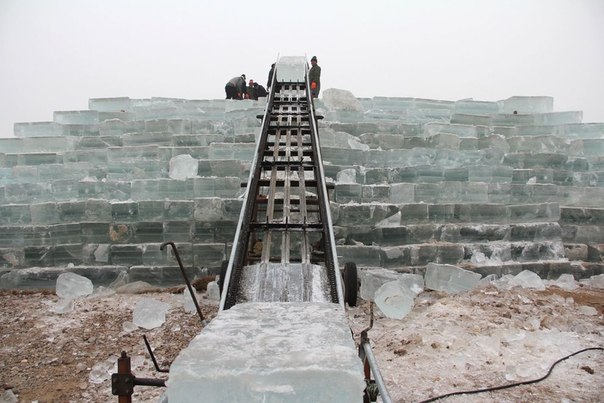 Рыбаки заготавливают вырезанный из замерзшей реки лед, чтобы продавать его летом, провинция Ляонин, Китай.